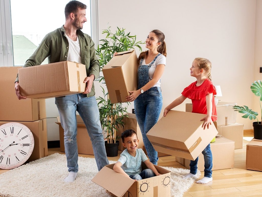 Famille avec enfants préparant les cartons d'un déménagement
